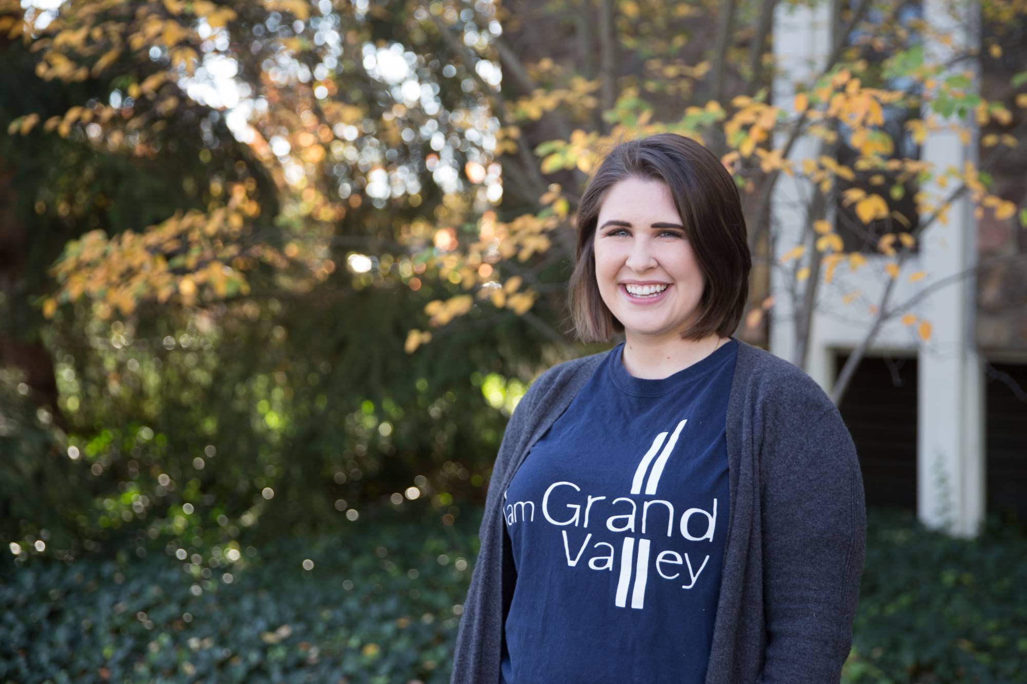"I am Grand Valley" student recipient head-shot in front of a lake building